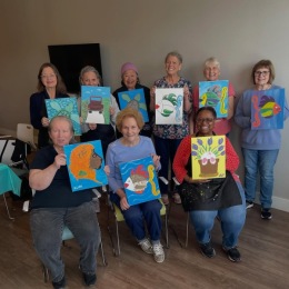 a group of people holding paintings