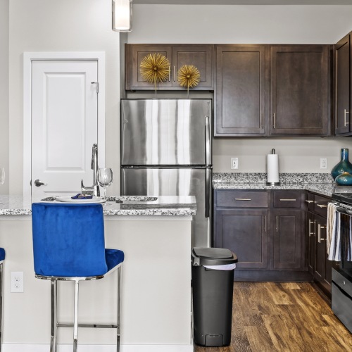 a kitchen with blue barstool chairs and cabinetry