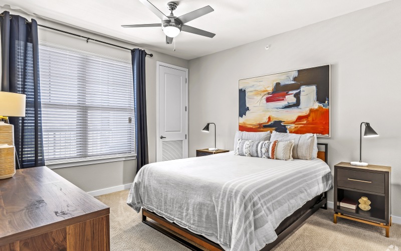 a room with a queen size bed, nightstands and a dresser
