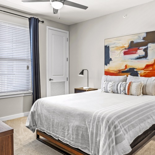 a room with a queen size bed, nightstands and a dresser
