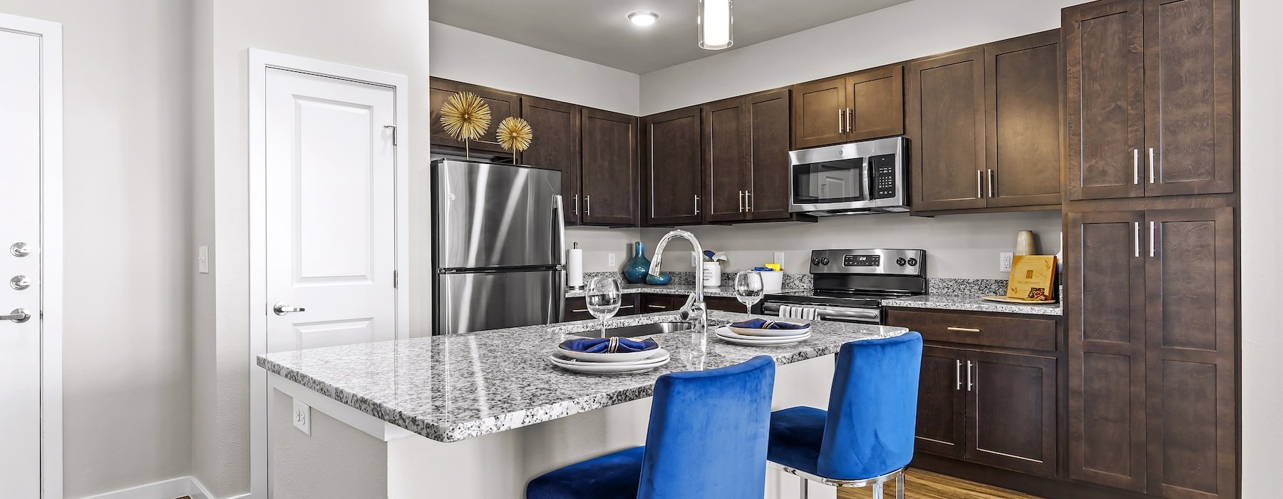Model kitchen at The Orchards at Arlington Highlands senior living apartments in Arlington, TX, featuring a kitchen island